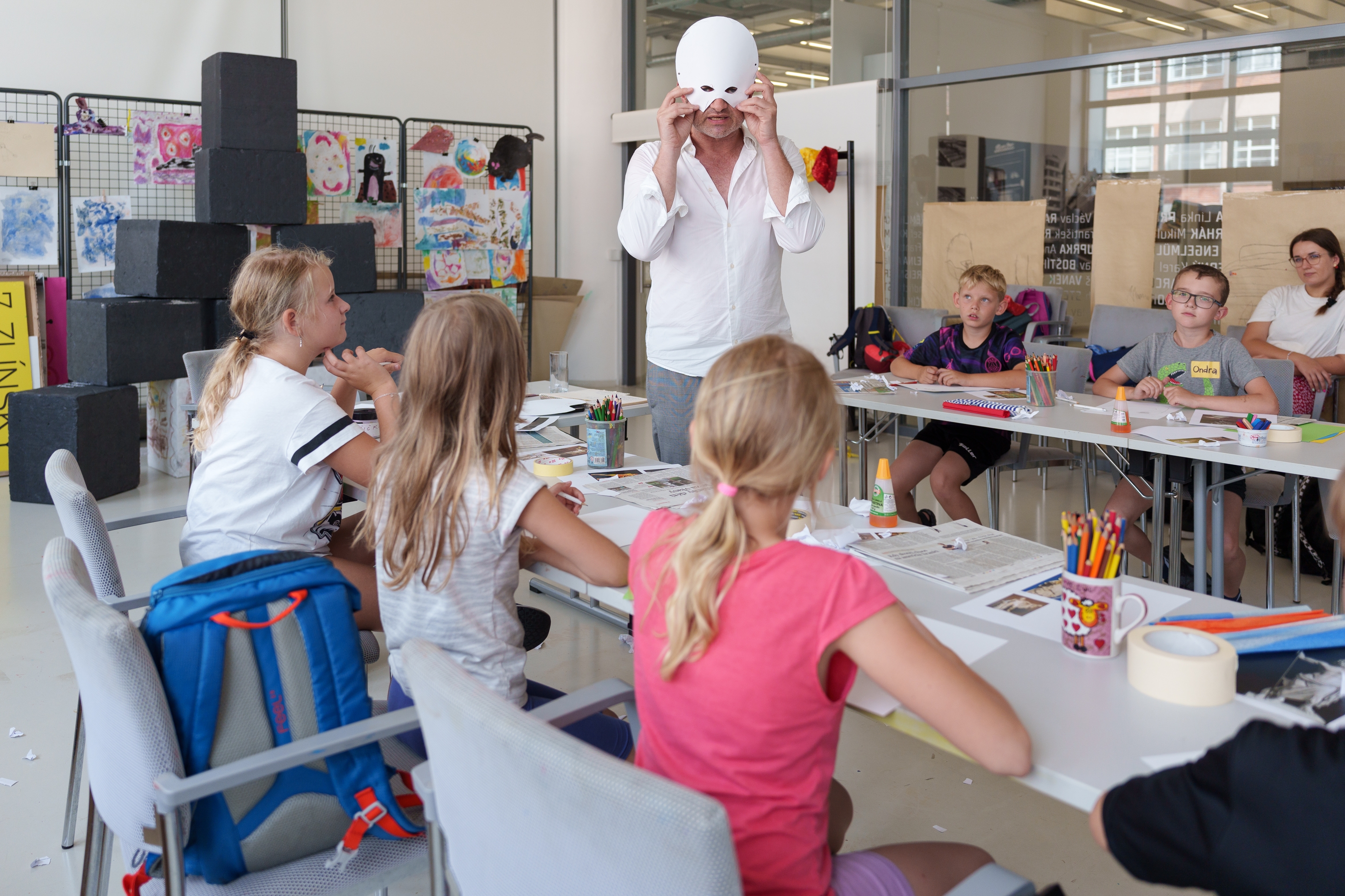edukátor s papírovou maskou hovoří k dětem 
